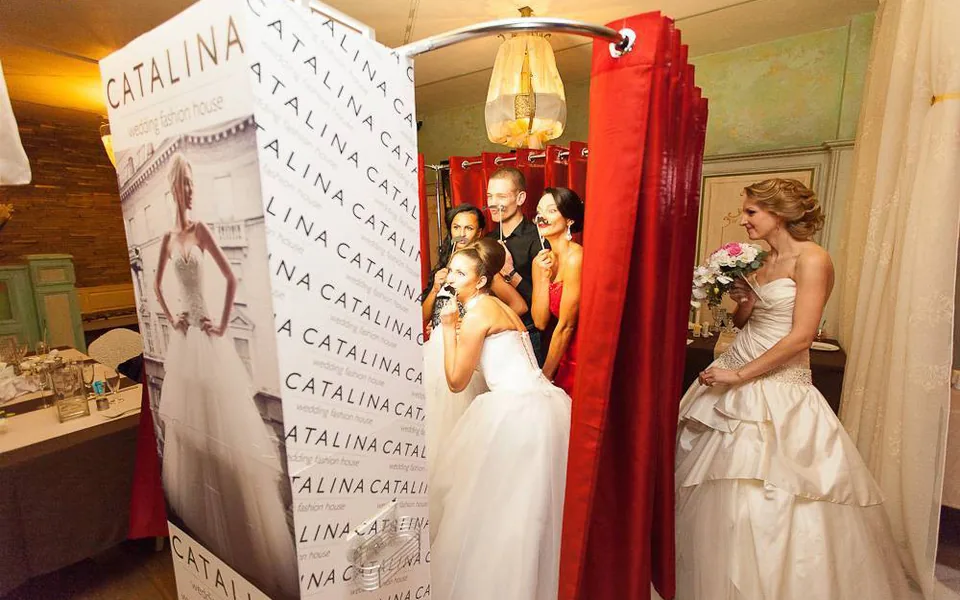 Wedding booth positioned beside a reception backdrop and guests