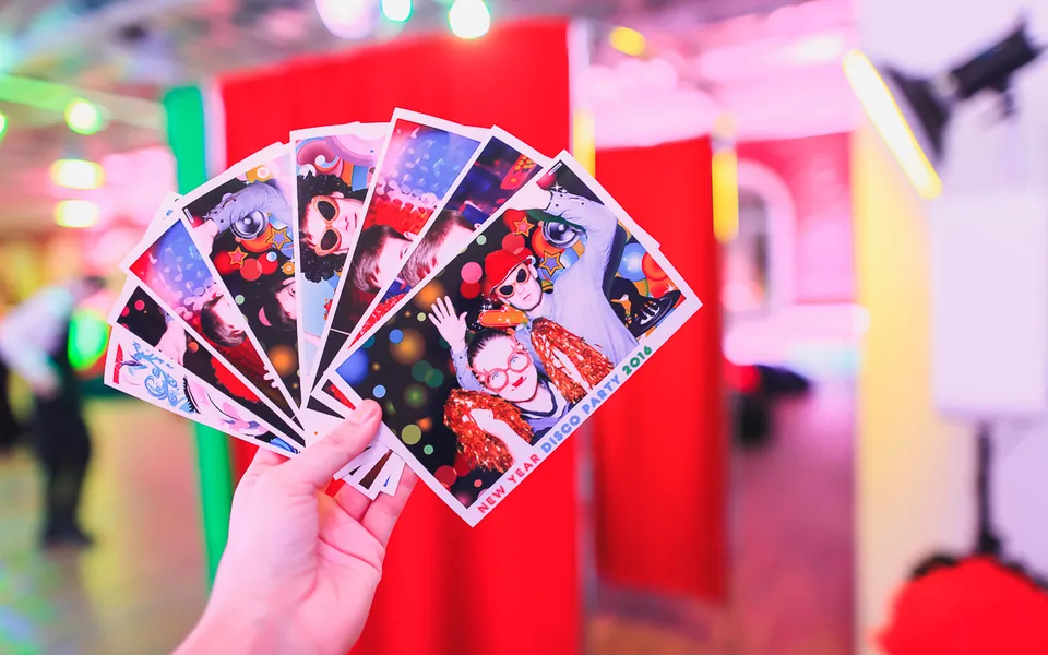 Printed photo strips held in front of a booth setup
