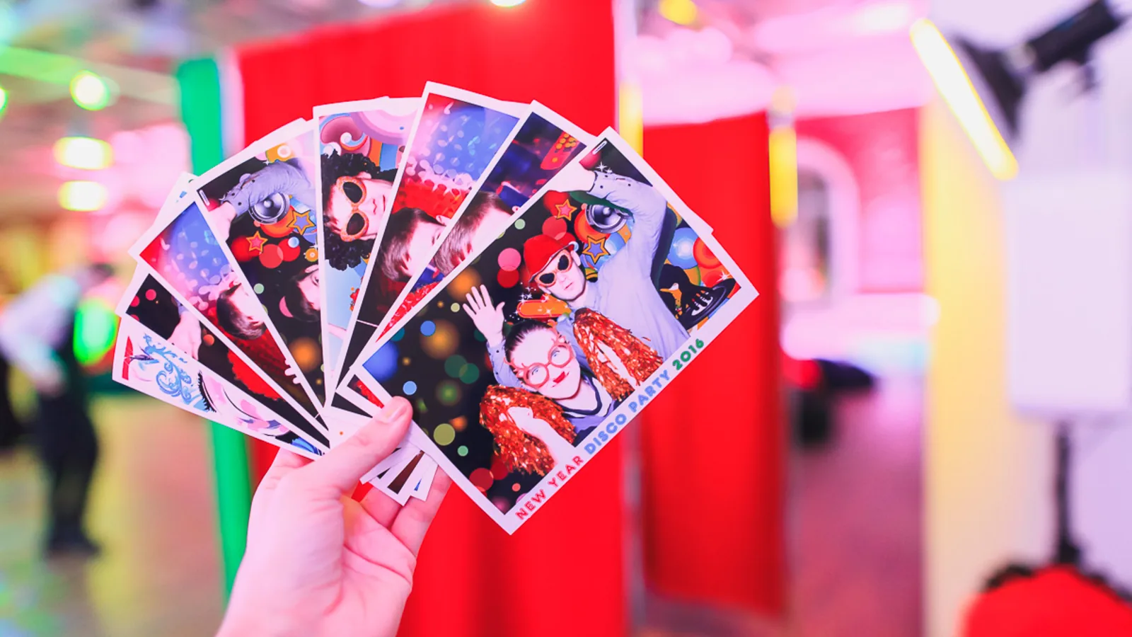Printed photo strips held in front of a booth setup