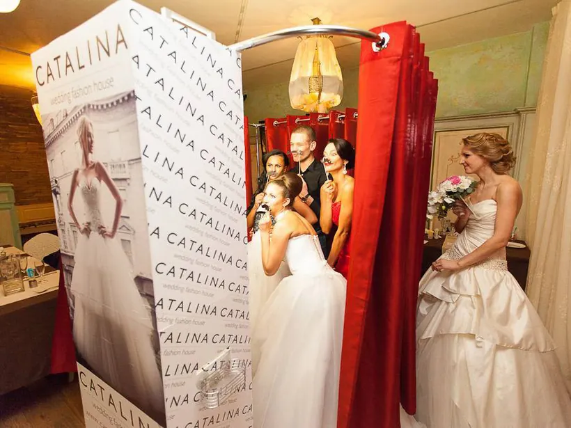 Wedding booth positioned beside a reception backdrop and guests