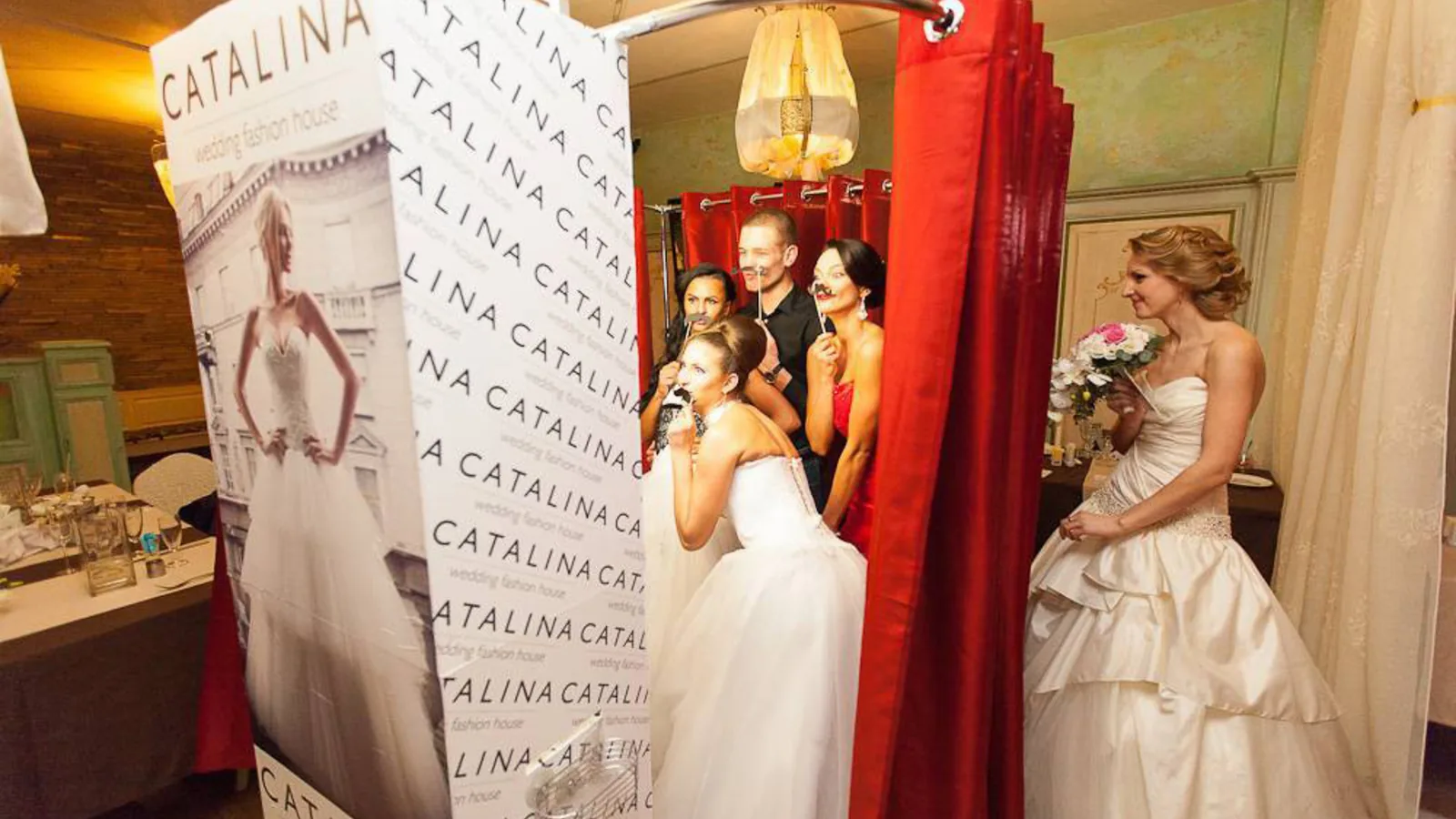 Wedding booth positioned beside a reception backdrop and guests