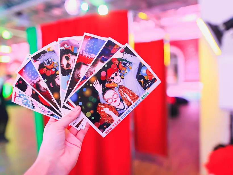 Printed photo strips held in front of a booth setup